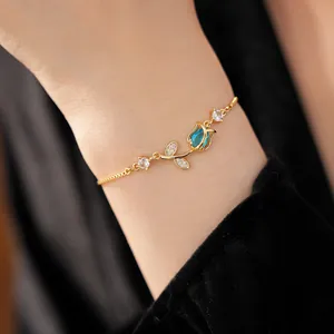 Elegant close-up detail of golden tulip bracelet featuring a blue zircon flower charm