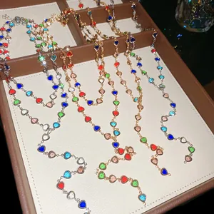 Detailed view of colorful heart-shaped crystal double-layered Y-shaped necklaces in a display box.
