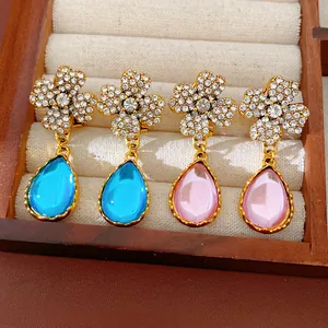 Close-up of vintage flower earrings with rhinestones and resin teardrop pendants