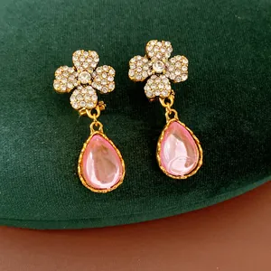 Detailed close-up of vintage flower stud earrings featuring pink teardrop resin pendants.