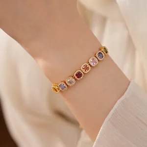 Elegant gold plated bracelet with square multicolor cubic zirconia on a female wrist