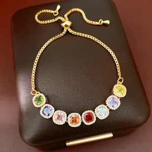 Macro view of adjustable gold-plated bracelet with eight colorful square-cut zircons