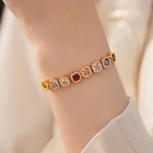 Detailed view of an elegant gold bracelet featuring vibrant square-cut colorful gemstones