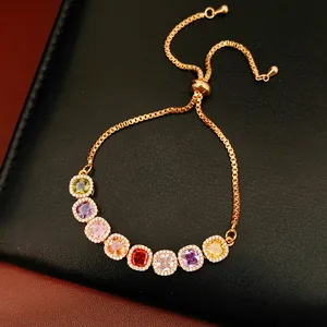 Detailed view of a gold adjustable bracelet featuring eight multi-colored square zircons.