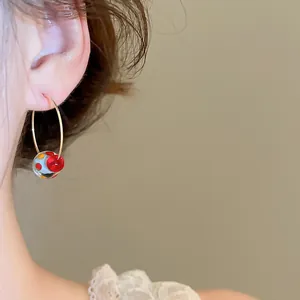 Primo piano di una modella con orecchini a cerchio in resina colorata stile dopamine.