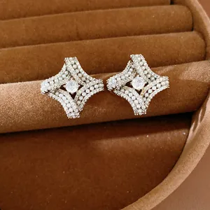 Vue rapprochée de boucles d'oreilles losanges torsadées avec perles et zircon central