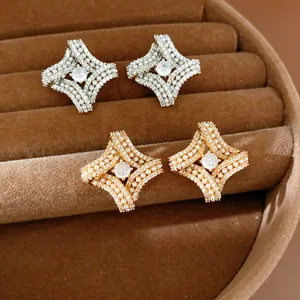 Gros plan de boucles d'oreilles losanges torsadées en or et argent avec perles et CZ