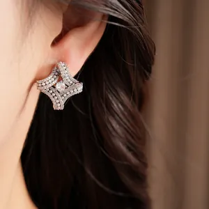 Gros plan de boucles d'oreilles losanges torsadées plaquées or 18K avec perles.