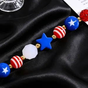 Macro shot of USA flag style beads with stars and stripes on black silk fabric