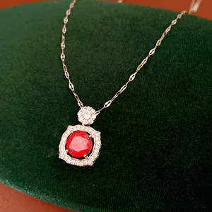 Close-up detail of a vintage-style silver necklace featuring a vibrant red gemstone