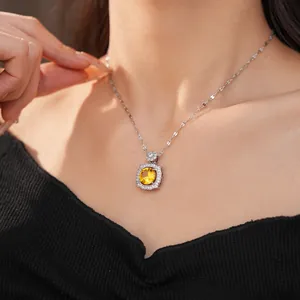 Close-up of elegant silver-toned necklace with brilliant yellow zircon pendant