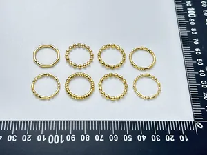 Detailed view of an 8-piece gold-plated bamboo and twisted ring set on a measuring mat