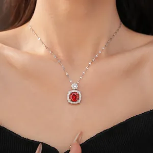 Close-up of an elegant silver necklace featuring a brilliant red zircon pendant
