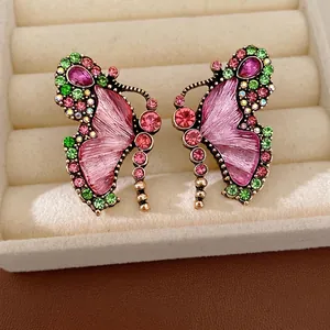 Vintage-style butterfly earrings with colorful rhinestones displayed in a velvet box
