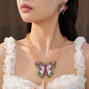 Detailed view of a vintage resin butterfly necklace and matching earrings with crystals