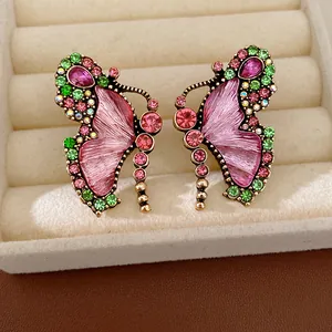 Detailed view of vintage butterfly earrings with pink resin and crystals.