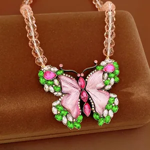 Detailed view of a vintage butterfly pendant necklace with pink and green rhinestones