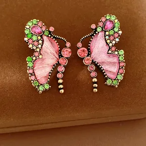 Close-up of vintage butterfly earrings with pink resin wings and rhinestones