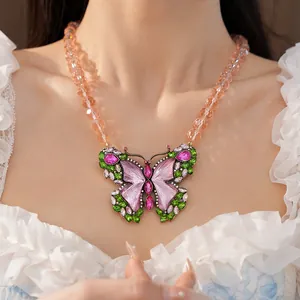 Macro view of vintage resin butterfly necklace with pink rhinestones on a beaded chain