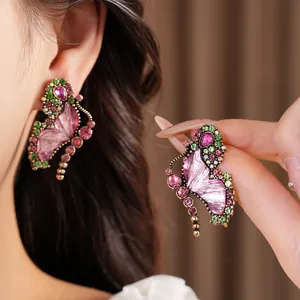 Detailed view of vintage butterfly earrings featuring pink resin and colorful rhinestones