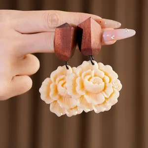 Macro detail view of ethnic wood and cream resin flower earrings with silver needles