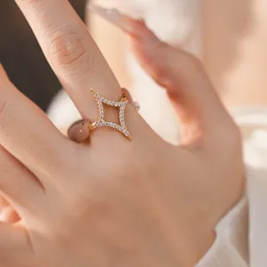 Close-up of a sparkling 18k gold-plated star ring with zirconia stones on a model hand.