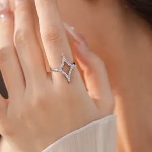 Elegant silver-colored open ring with zircon-encrusted north star design on finger.