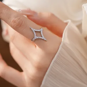 Macro detail of a shimmering silver four-pointed star open ring with zircon stones