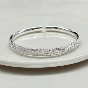 Detail of matte starry finish and polished silver surface on adjustable bangle