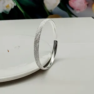 Detail of matte starry finish on adjustable sterling silver bangle with polished interior