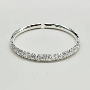 Close-up of adjustable 990 silver cuff with frosted exterior and polished inner surface