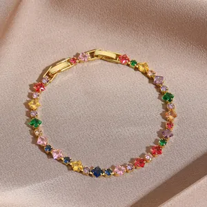 Macro view of gold tennis bracelet featuring multi-colored cubic zirconia and clasp detail