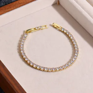 Detailed close-up of golden tennis bracelet with sparkling zircons in a jewelry box