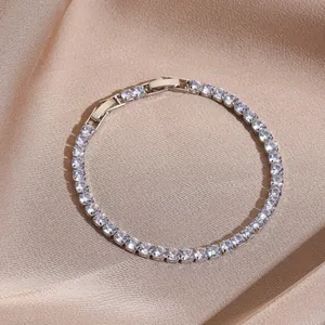 Detailed close-up of sparkling tennis bracelet with round cubic zirconia on champagne silk