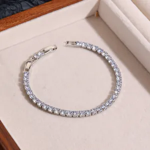 Detail of silver tennis bracelet with round cubic zirconia in a beige jewelry box