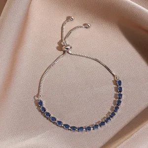 Detail of adjustable box chain bracelet with 20 blue pear-cut zircon stones on silk background