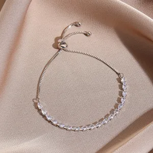 Detail of adjustable silver bracelet with sparkling marquise zirconia on silk fabric