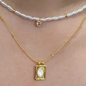Details von geschichteten Goldketten mit Zirkon-Anhänger und Muschel-Quadrat-Medaillon