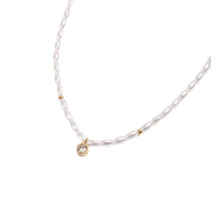 Elegante collana di perle con pendente di diamante centrale e perline d'oro su sfondo bianco