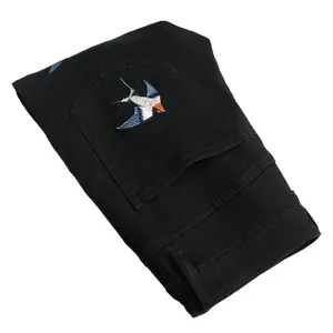 Slim fit black stretch denim jeans for men with colorful swallow embroidery on back pocket