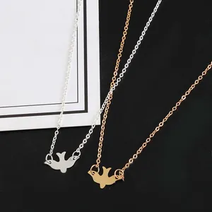 Detail of minimalist peace dove pendant necklaces in gold and silver metallic finishes