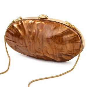 Detail of acrylic shell clutch bag featuring brown marble texture and golden metal frame
