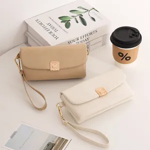 Detailed view of textured PU leather handbags with elegant metal clasps and wrist straps