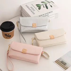 Detailed close-up of textured PU leather handbags with leaf pendant and golden metal clasps