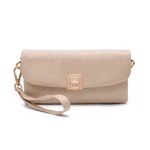 Close-up of a beige PU leather clutch with wrinkled texture and gold leaf pendant buckle
