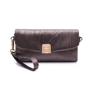 Detail of metallic bronze handbag featuring wrinkled texture and gold rectangle clasp lock