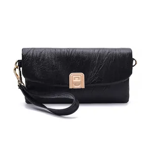 Detailed view of black pleated leather wallet with a gold metal buckle and wrist strap