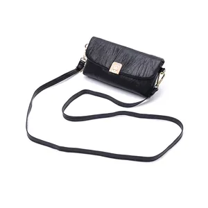 Close-up of black pleated PU leather crossbody bag featuring a vintage gold metal lock