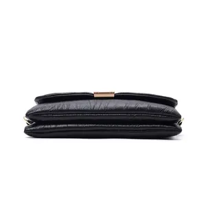 Close-up of black wrinkled leather bag featuring gold hardware and layered structure