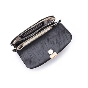Internal view of black textured mini crossbody bag with card slots and multiple compartments